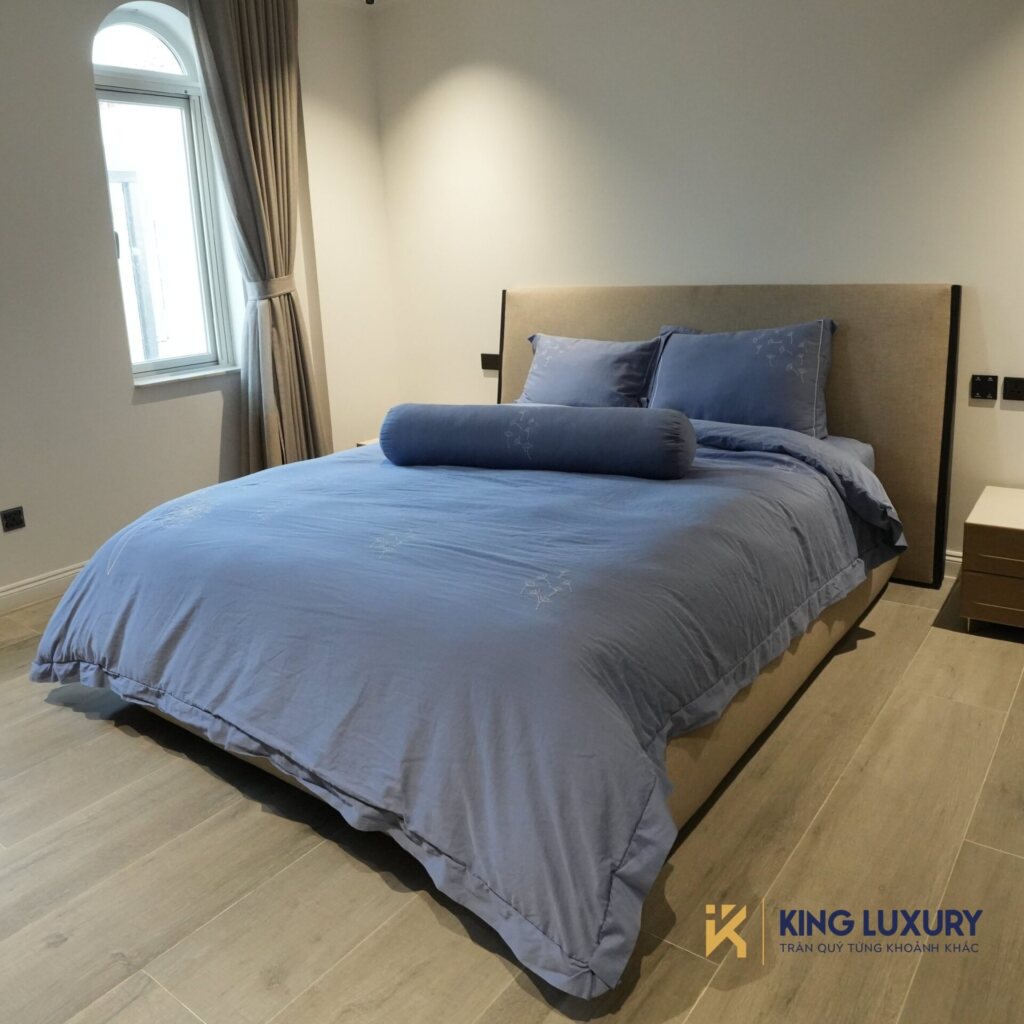 Phòng ngủ đơn với bộ chăn ga xanh tại Minh Tâm Long Biên